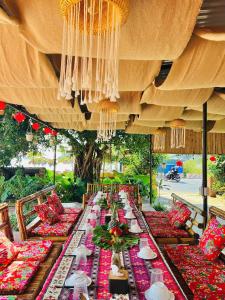 a long long table with red and green tables and chairs at Woodstock Beach Camp in Cat Ba