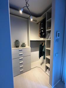 a walk in closet with white cabinets and a blue door at Fusa e Barbera in Asti