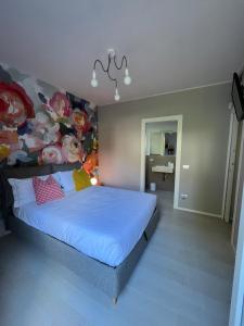 a bedroom with a bed with a flower wall at Fusa e Barbera in Asti