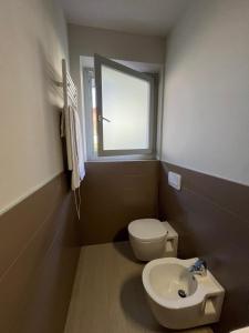 a bathroom with a toilet and a sink and a window at Fusa e Barbera in Asti