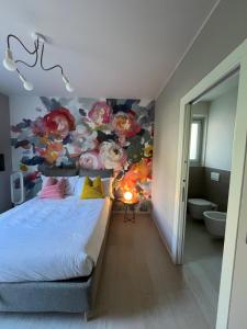 a bedroom with a painting of flowers on the wall at Fusa e Barbera in Asti