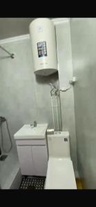a white bathroom with a toilet and a sink at Panoramic view in Tamga