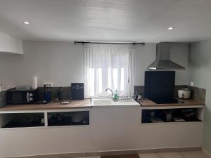 a kitchen with a counter with a sink and a window at L'appart de juju in Petite Île