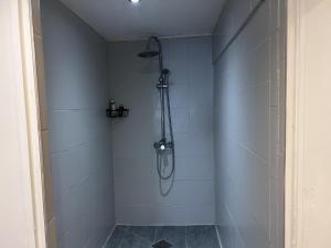 a bathroom with a shower with white tiles at L'appart de juju in Petite Île +4 photos