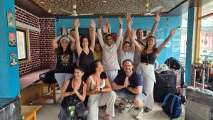 a group of people with their hands in the air at Manzil Hostel in Rishīkesh