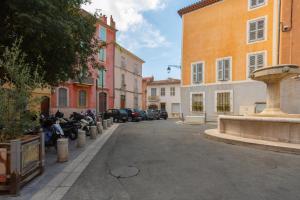 a city street with a fountain and buildings at Le Loft 11 Draguignan in Draguignan