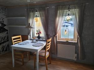 a dining room with a table and chairs and a window at Muminhuset i Norberg in Norberg