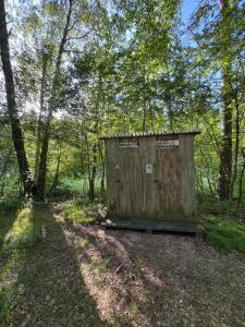 a wooden outhouse sitting in the middle of a forest at Vaide kempings in Vaide