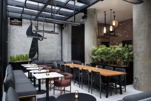 a restaurant with tables and chairs and plants at The Livingston, part of JdV by Hyatt in Brooklyn