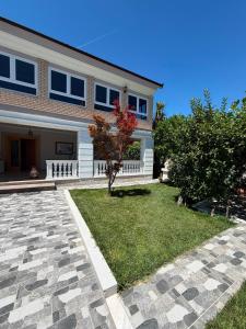 a house with a stone driveway in front of it at Vila Hysaj in Kamëz