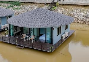 a house on a floating deck in the water at แพ River Tale Uthaithani in Ban Khok Mo