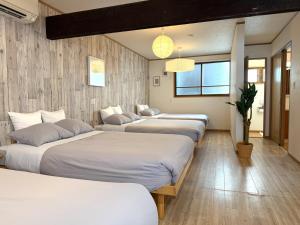 a row of beds in a room at 金森赤レンガ倉庫徒歩すぐ 伝統建築リノベ貸切 最大8名 最新設備 in Hakodate