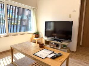 a living room with a large flat screen tv at 金森赤レンガ倉庫徒歩すぐ 伝統建築リノベ貸切 最大8名 最新設備 in Hakodate