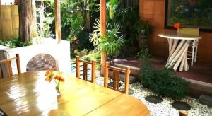 a wooden table with flowers on top of a patio at Gerard Habitat Hotel in Chiang Mai