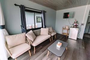 a living room with two couches and a table at แพ River Tale Uthaithani in Ban Khok Mo