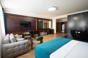 a bedroom with a bed and a bathroom with a sink at Alegria Hotel in Prizren