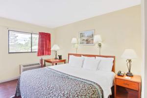 a hotel room with a large bed and two tables at Days Inn by Wyndham Athens in Athens