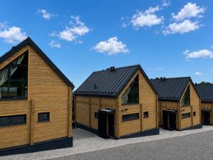 a row of wooden homes with black roofs at Góry i Chmury in Duszniki Zdrój