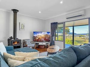 a living room with a blue couch and a tv at Pebblebrook in Millfield