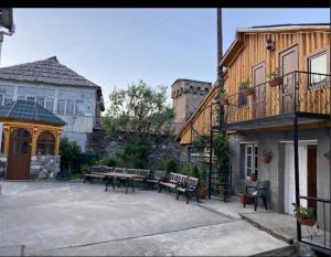 a patio with benches and a building with a building at Family hotel ucha in Iprari
