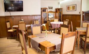 a dining room with tables and chairs and a flat screen tv at Hotel Royal Victoria in Victoria