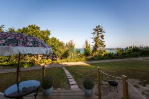 a patio with a table and chairs and an umbrella at JOY Retreat in Isle of Jersey +11 photos