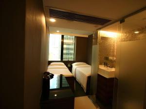 a small bathroom with a bed and a sink at J Link Hotel in Hong Kong +106 photos