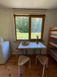 a table and chairs in a room with a window at Vaide kempings in Vaide