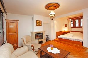 a living room with a bed and a fireplace at Family Hotel and Restaurant Varosha 2003 in Lovech