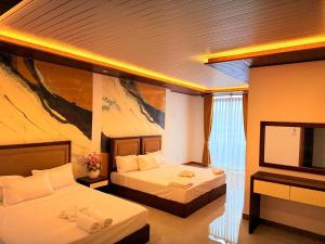a hotel room with two beds and a flat screen tv at Bravon Sky Hotel in Kurunegala