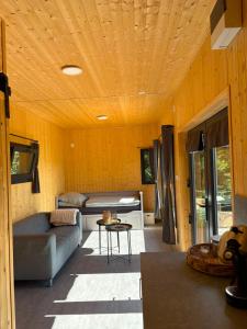 a living room with a couch and a bed at TINY Klíny in Klíny