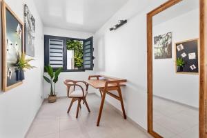 a dining room with a wooden table and a chair at Villa T4 La Sagesse WS - Piscine Privée in Rivière-Salée