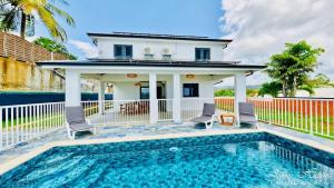 a house with a swimming pool in front of a house at Villa T4 La Sagesse WS - Piscine Privée in Rivière-Salée +25 photos