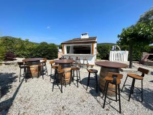 a group of tables and stools in front of a grill at Stella Marina in Macinaggio