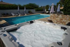 a hot tub in front of a swimming pool at Stella Marina in Macinaggio