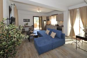 a living room with a blue couch and a kitchen at Olivia Villas in Raches