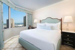 a bedroom with a large bed and a large window at The Windsor Court in New Orleans