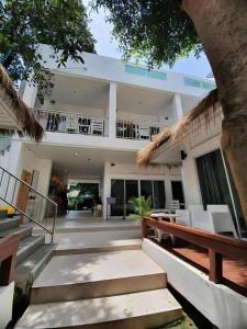 a large white building with stairs and a balcony at Sawasdee Coco Resort in Ko Samed
