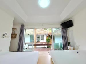 a white living room with a view of a patio at Sawasdee Coco Resort in Ko Samed