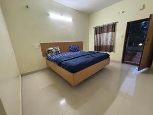 a bedroom with a bed with blue sheets and a window at Holidaypark Resort Araku in Araku