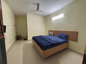 a bedroom with a bed with a blue comforter and a ceiling at Holidaypark Resort Araku in Araku