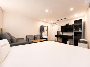 a room with a bed and a living room with furniture at Hotel Yaja Gwangalli in Busan