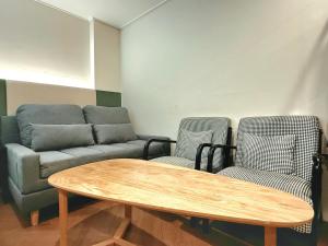 a living room with a couch and two chairs and a table at Hotel Yaja Gwangalli in Busan
