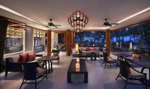 a restaurant with tables and chairs and a chandelier at Hyatt Regency Hua Hin in Hua Hin