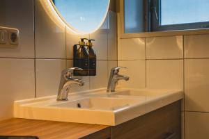 a bathroom with a sink and a mirror at Stijlvol 4-6 pers "Vakantiehuis De Meierij" - compleet ingericht huis met vrij weidezicht in Schijndel +62 photos
