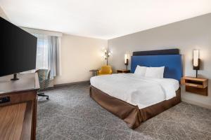 a hotel room with a bed and a flat screen tv at Hampton Inn Carbondale in Carbondale