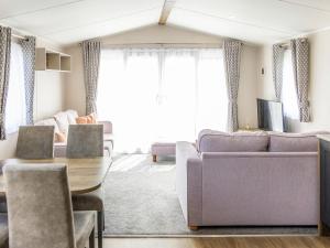 a living room with a couch and a table at Astra - Ukc9718 in Aston +2 photos