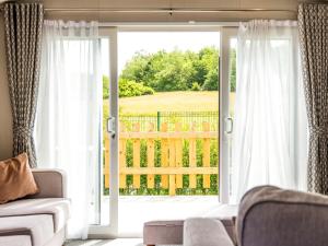 a living room with a large sliding glass door at Astra - Ukc9718 in Aston