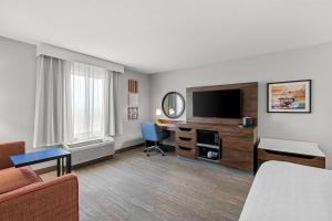 a hotel room with a bed a desk and a television at Hampton Inn and Suites Peru in Peru
