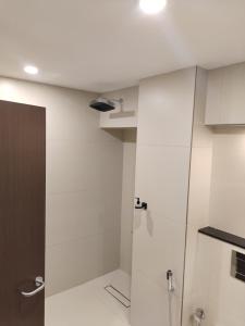 a bathroom with white walls and a shower stall at Hotel Elite International in Trichūr +1 photo